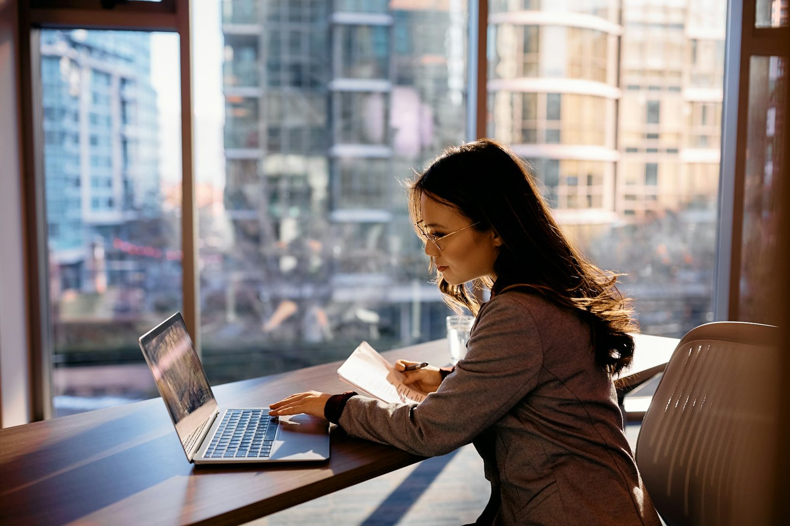 Asian female entrepreneur using computer while working at corporate office.